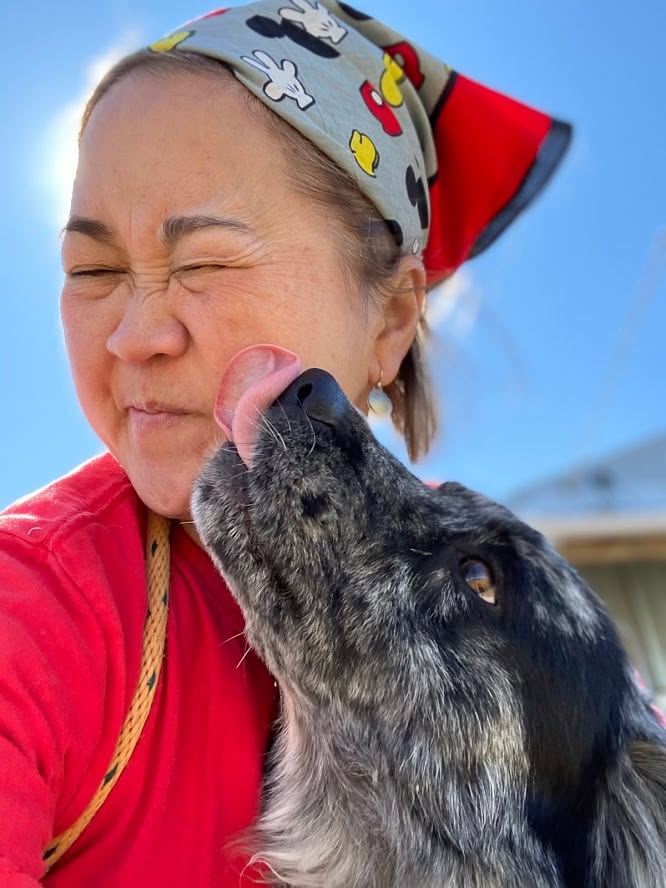 Missy Liu’s team member sharing an affectionate moment with a dog during daycare in Farmington, Arkansas